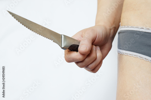 Fotografía Female hand holds steel sharp knife on white background