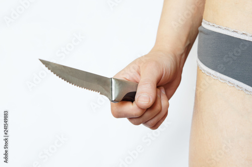 Cuadro en lienzo Female hand holds a sharp knife on a white background