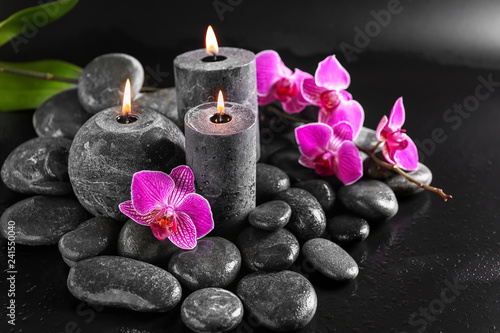 Candles  flowers and spa stones on dark background