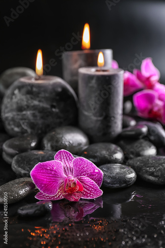 Candles  flowers and spa stones on dark background