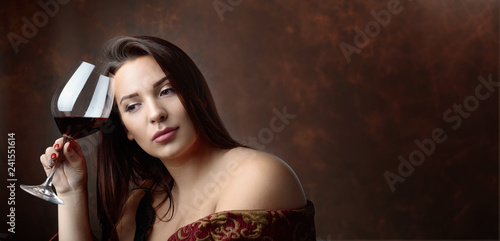 Portrait of a beautiful young woman with glass of red wine.
