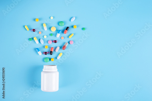 Tablets and bottle on blue background
