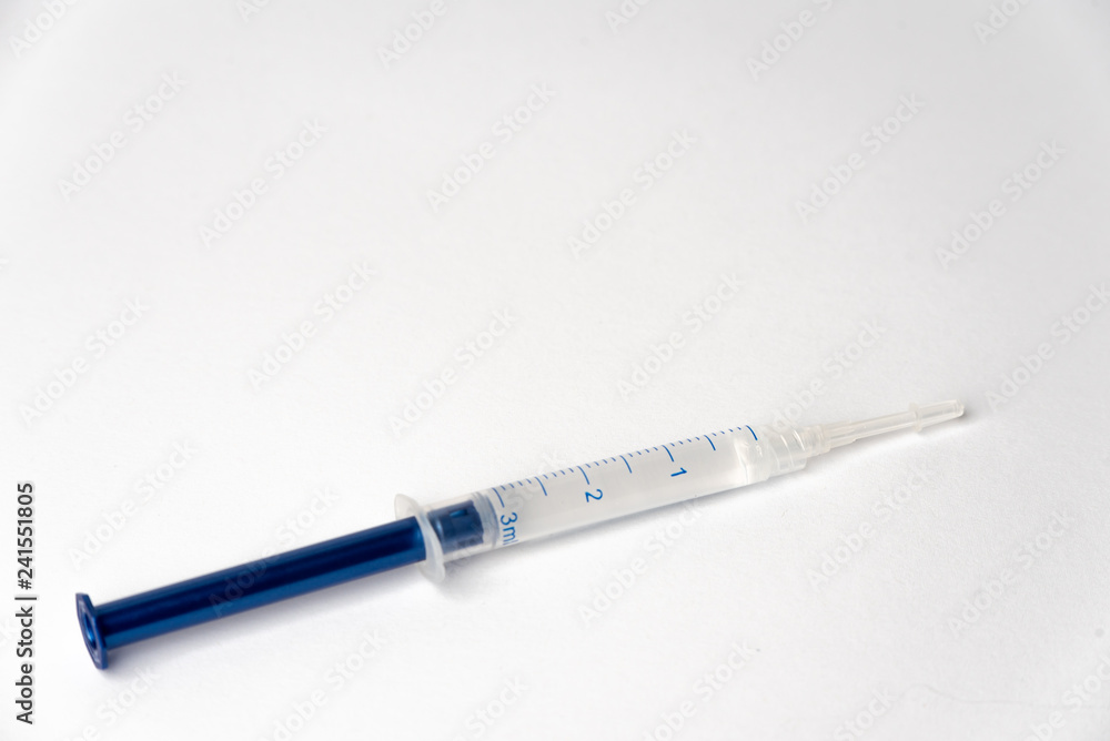 Syringe filled with liquid on a white background Syringe filled with liquid on a white background