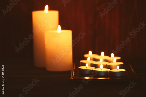 Beautiful burning candles on dark wooden background