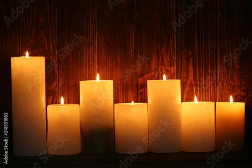 Beautiful burning candles on dark wooden background