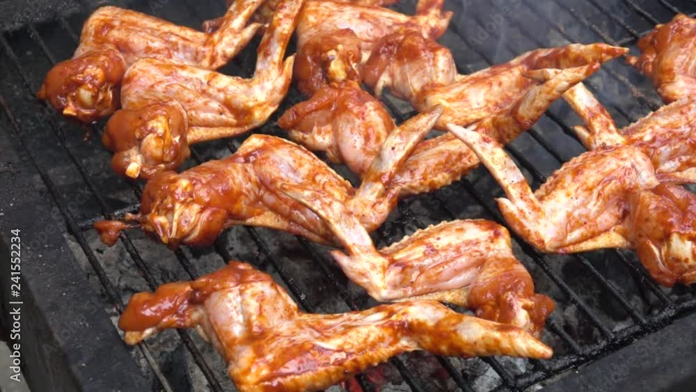 Meat chicken wings grilled. Chicken raw wings on barbecue. Slow motion Meat chicken wings grilled. Chicken raw wings on barbecue. Slow motion