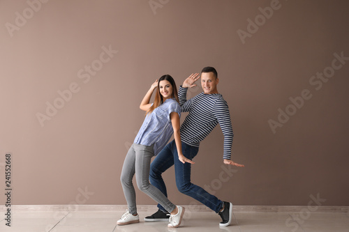 Couple of young dancers near color wall