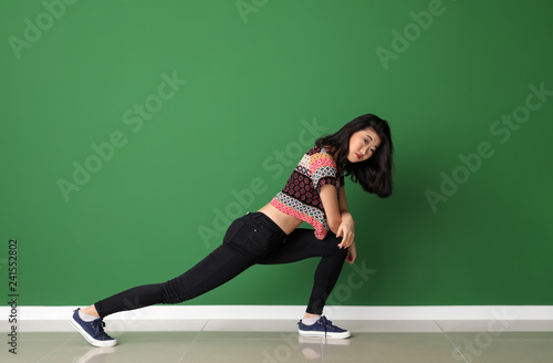 Female Asian dancer near color wall