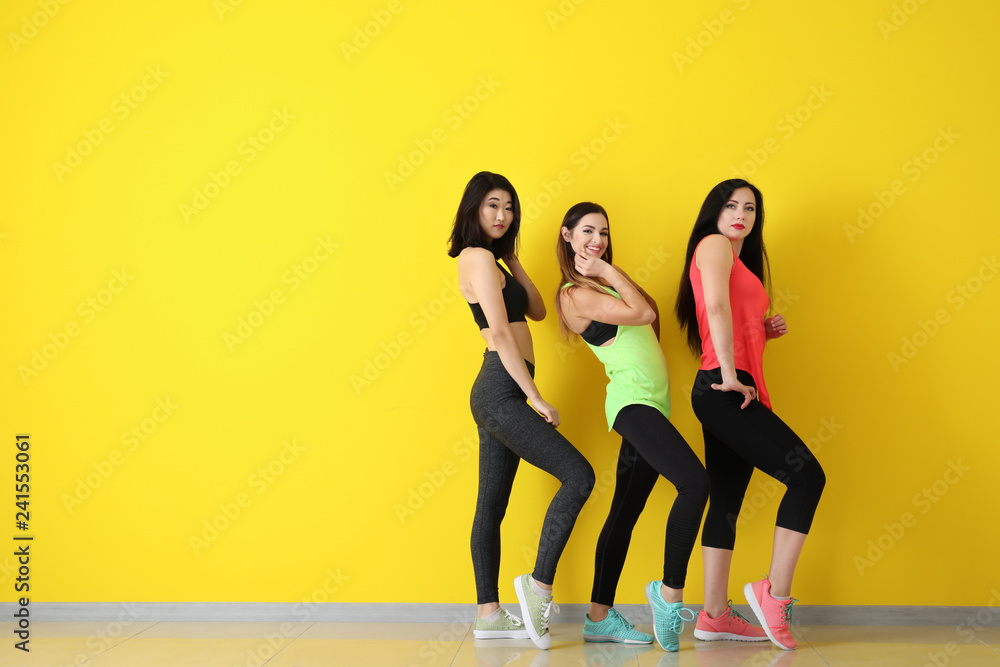 Obraz premium Team of young dancers near color wall