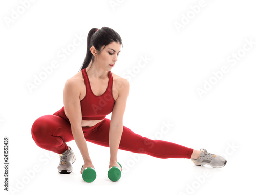 Sporty muscular woman with dumbbells on white background