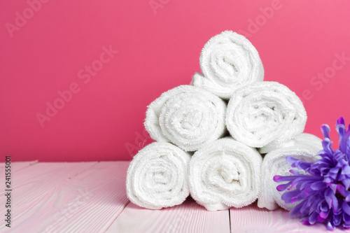 clean soft towels with flower on wooden table