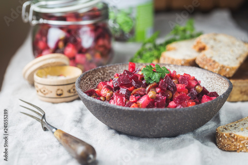 Russian beetroot salad vinaigrette in a bowl with rye bread  rustic background