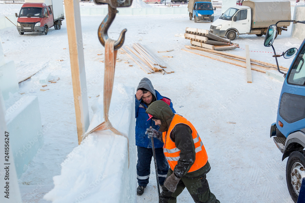 Fototapeta premium Workers on the installation of the ice town