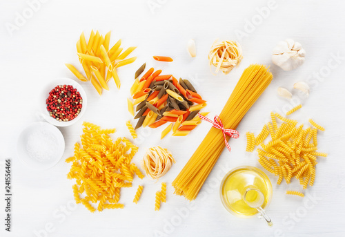assorted raw pasta flat lay on white. spaghetti fusilli penne tagliatelle girandole