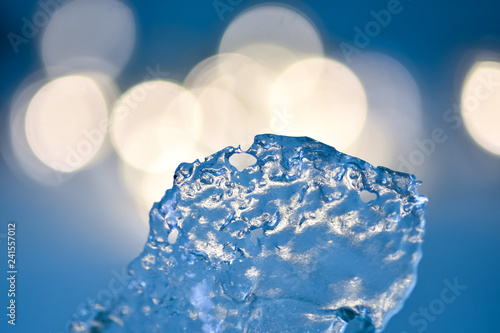 Natural piece of ice on the background of glowing lights