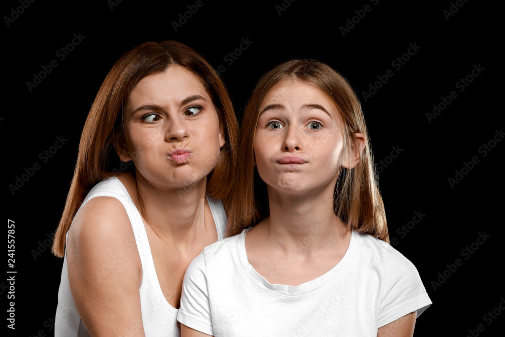 Portrait of funny mother and daughter on dark background Portrait of funny mother and daughter on dark background