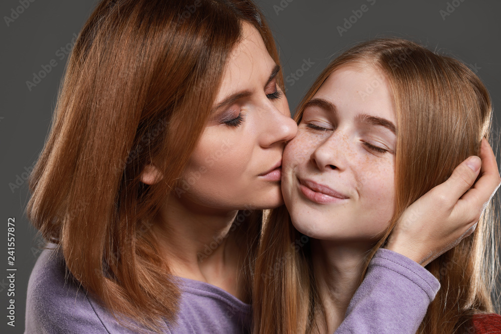 Portrait of happy mother and daughter on grey background Portrait of happy mother and daughter on grey background