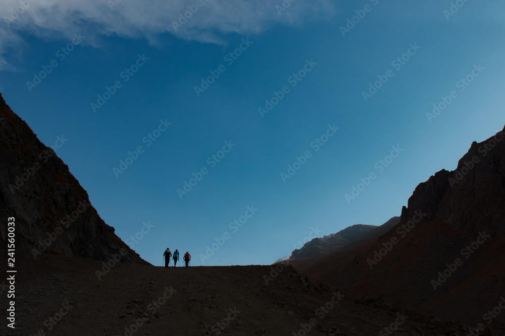 Adventurous man is standing on top of the mountain and enjoying the beautiful view during a vibrant sunset Adventurous man is standing on top of the mountain and enjoying the beautiful view during a vibrant sunset