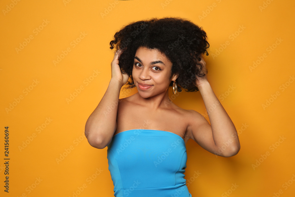 Portrait of young African-American woman on color background - obrazy, fototapety, plakaty 