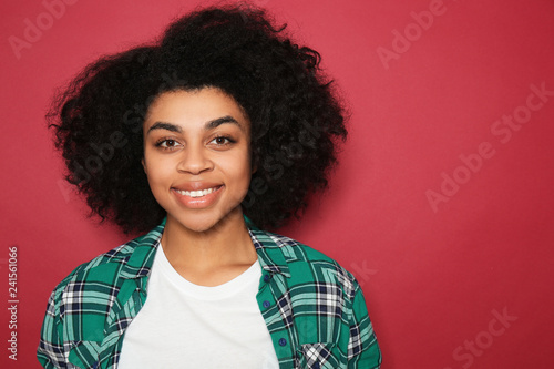 Portrait of young African-American woman on color background