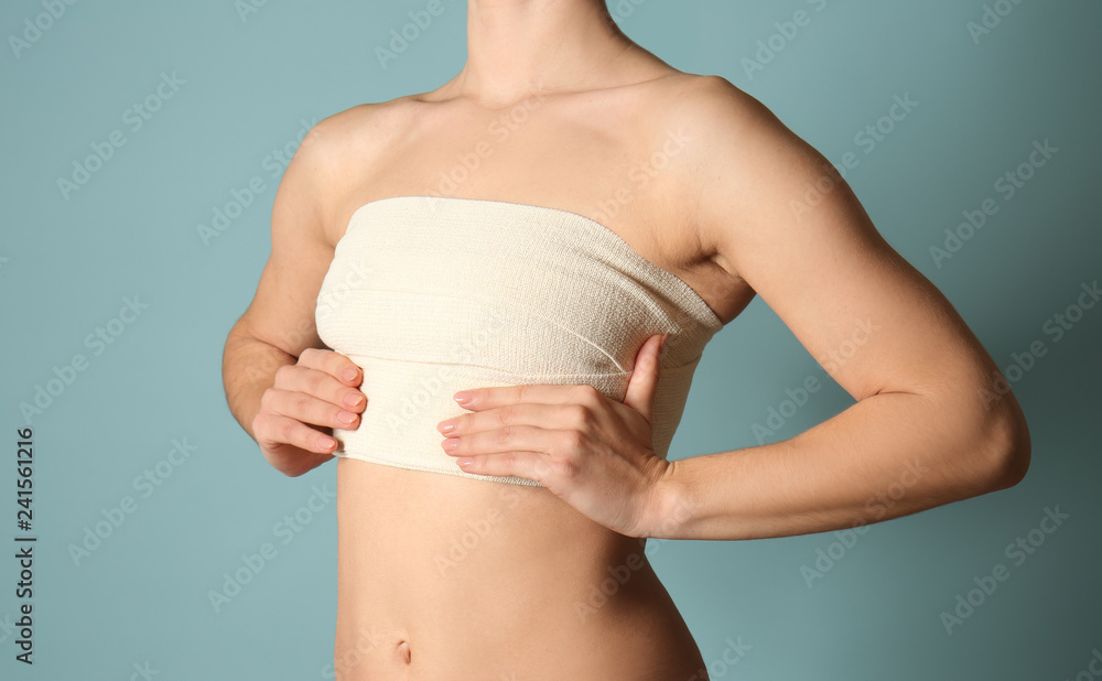 Woman with bandage on her chest against color background. Breast  augmentation concept Stock-Foto | Adobe Stock
