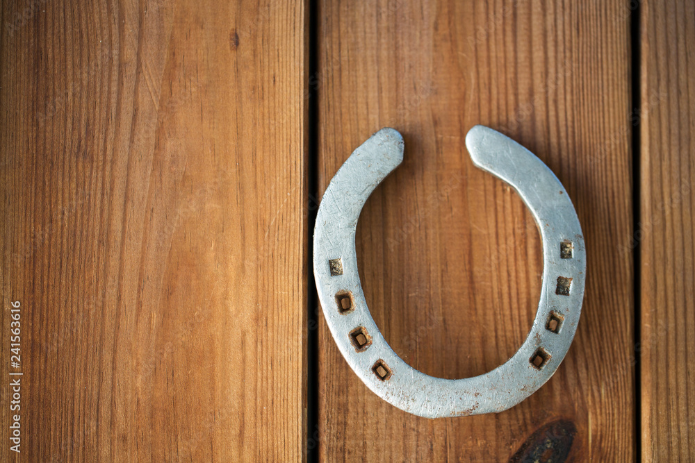 fortune and good luck concept - old horseshoe on wooden background fortune and good luck concept - old horseshoe on wooden background