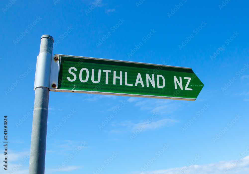 Green color Street name signs showing the direction in the big city of Southland, New Zealand, Isolated on blue sky background. Green color Street name signs showing the direction in the big city of Southland, New Zealand, Isolated on blue sky background.