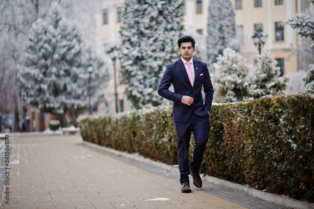 Elegant indian macho man model on suit and pink tie posed on winter day.