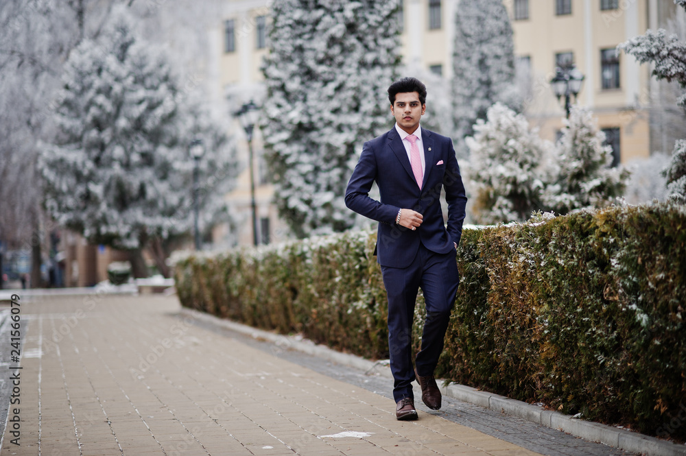 Elegant indian macho man model on suit and pink tie posed on winter day. Elegant indian macho man model on suit and pink tie posed on winter day.