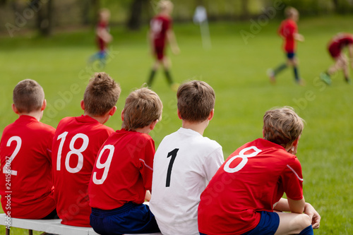 Kids Football Team. Children Football Academy. Substitute Soccer Players Sitting on Bench. Young Boys Playing European Football Game. Soccer Tournament Match for Children