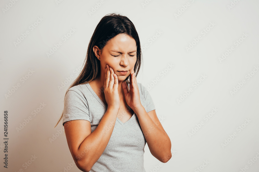 unhappy woman feel pain on her teeth isolated on gray background unhappy woman feel pain on her teeth isolated on gray background