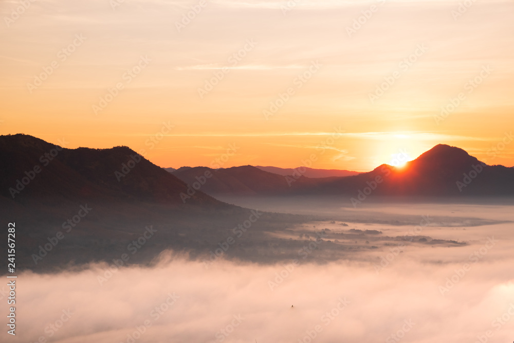 Fototapeta premium Poranna atmosfera w Mueang Loei Chiangkhan z ciepłym tonem i pasmem górskim pokrytym mgłą