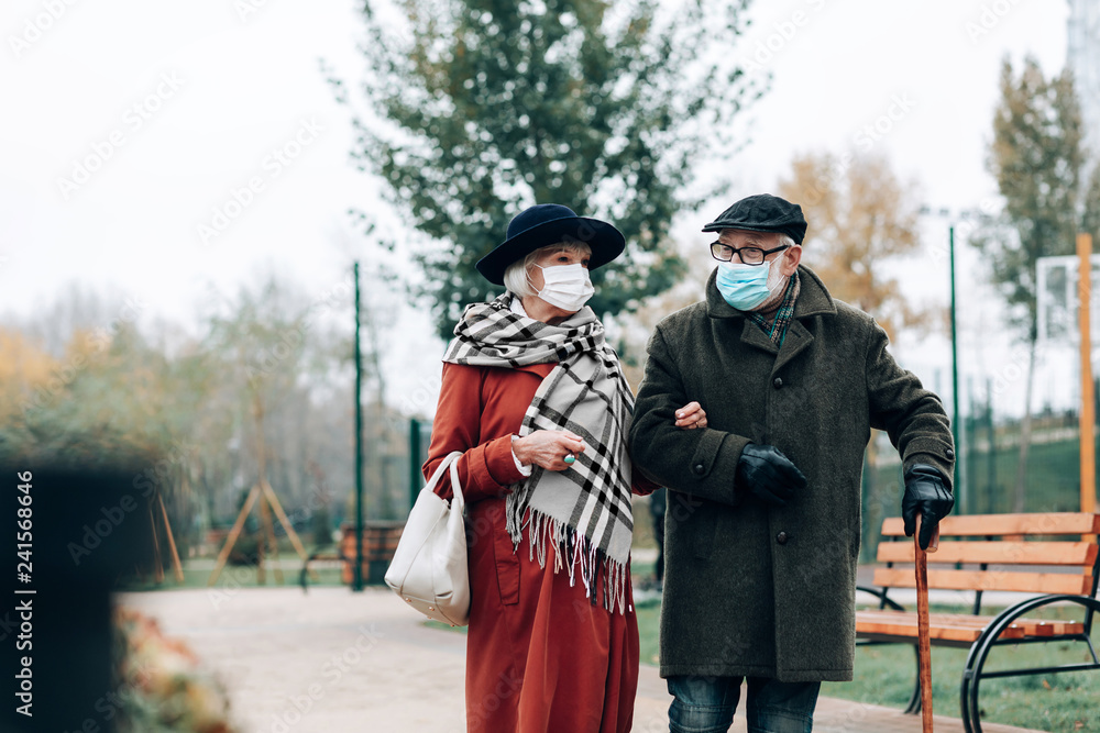 Cheerful elderly people walking during city epidemic