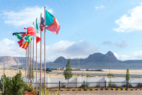 Several flags of different countries on flagpoles near the roadside restaurant in the south of Jordan, not far from Maan city photo