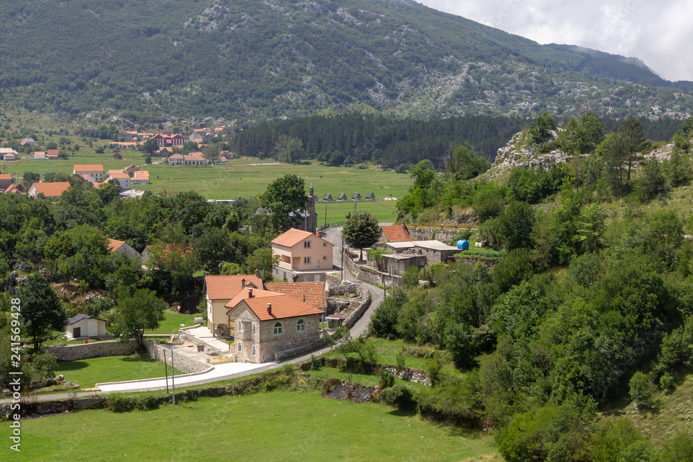 Small Njegusi village in Montenegro, located on a green valley at the foot of the mountains