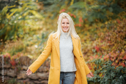 Fashion lifestyle portrait of young happy blond woman laughing and having fun in the city park at nice sunny day. bright fresh colors