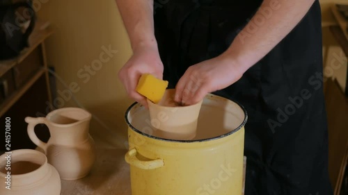 Wallpaper Mural Professional male potter preparing ceramic wares for burning in pottery kiln with milk - old russian pottery tradition. Crafting, artwork and handmade concept Torontodigital.ca