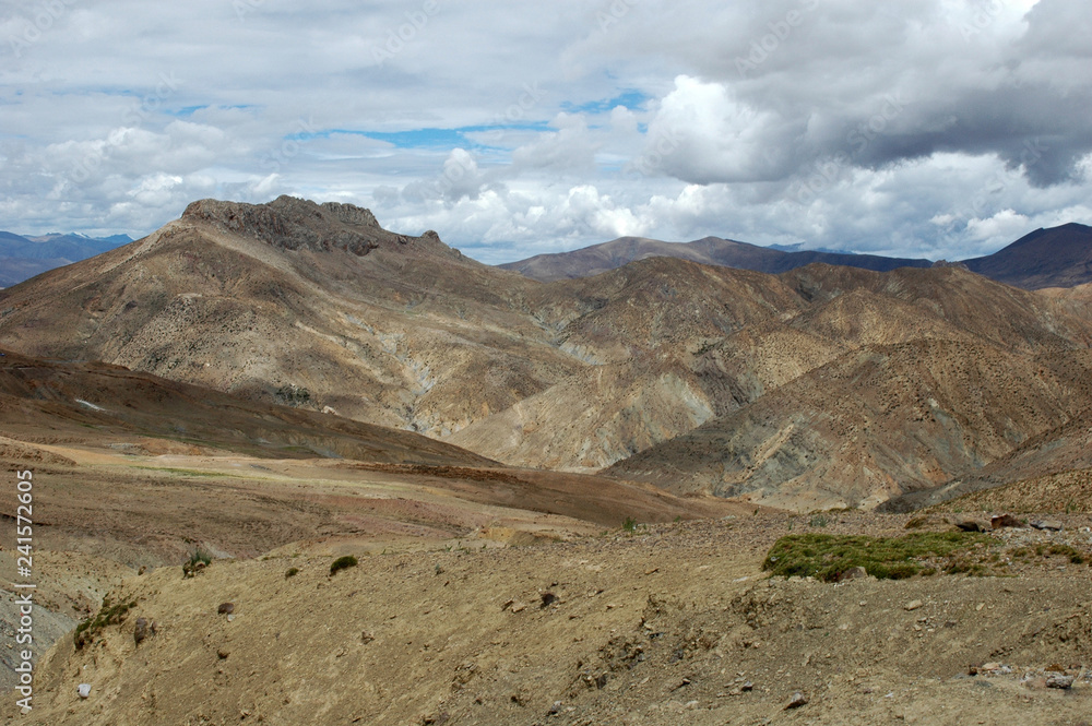 Tibetan landscape with brown mountains and clouds Tibetan landscape with brown mountains and clouds