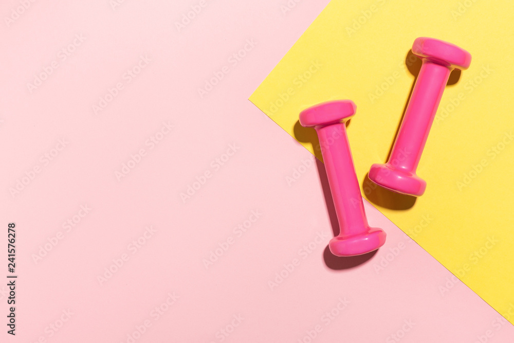 Dumbbells flat lay on pink and yellow - obrazy, fototapety, plakaty 