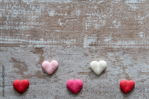Cozy wooden background, with colorful hearts at the bottom, love concept, for Valentine's Day, Mother's Day, Father's Day, Christmas, holidays.