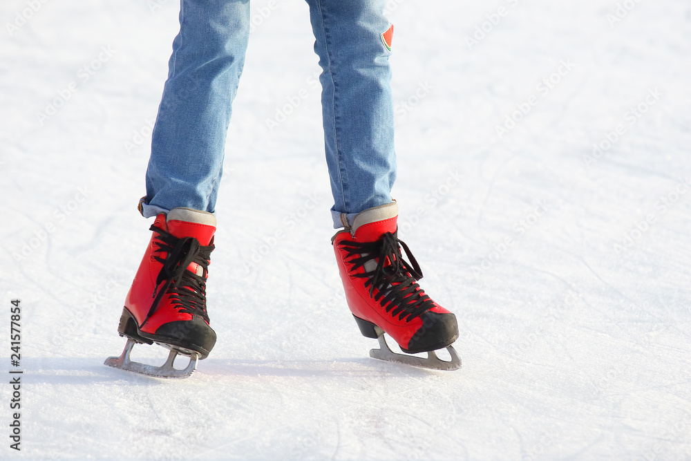 Female legs in skates on an ice rink Female legs in skates on an ice rink