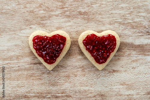  2 heart-shaped sandwich bread in a corner, with strawberry jam on a cozy wooden background, love concept, for Valentine's Day, Mother's Day, Father's Day, Christmas, holidays.