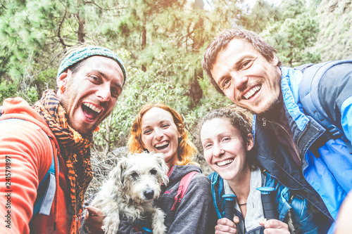 Happy trekkers people taking selfie for social network story with their dog photo