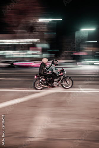 Motorradfahrt durch eine Stadt bei Nacht