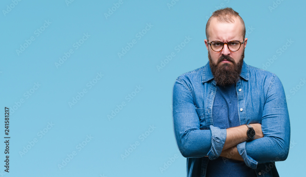 Obraz premium Young caucasian hipster man wearing glasses over isolated background skeptic and nervous, disapproving expression on face with crossed arms. Negative person.