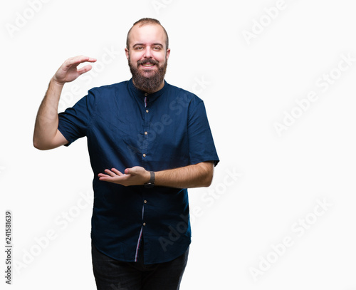 Young caucasian hipster man over isolated background gesturing with hands showing big and large size sign, measure symbol. Smiling looking at the camera. Measuring concept.