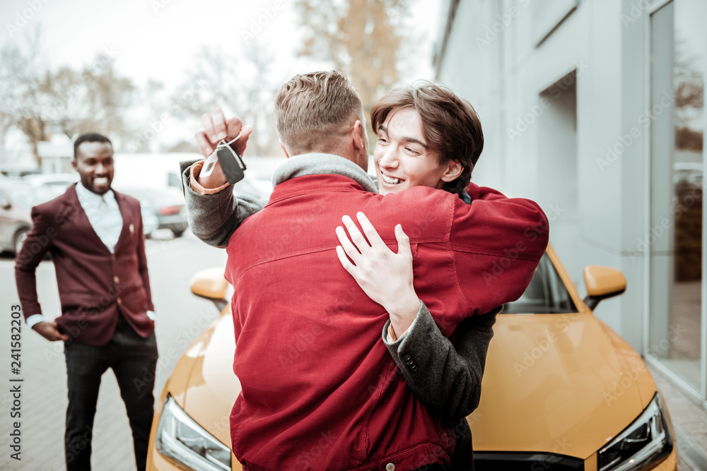 © Viacheslav Yakobchuk - Happy young son hugging his father after receiving his car keys