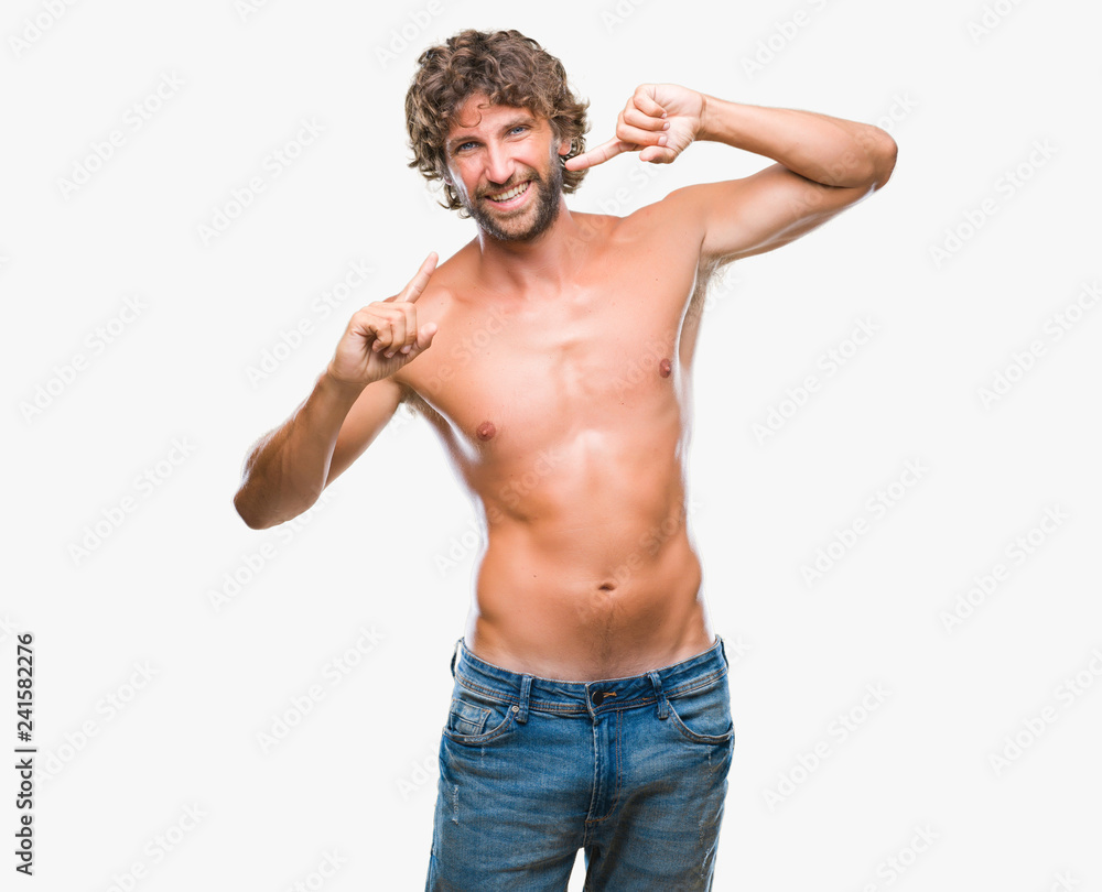 Fototapeta premium Handsome hispanic model man sexy and shirtless over isolated background smiling confident showing and pointing with fingers teeth and mouth. Health concept.