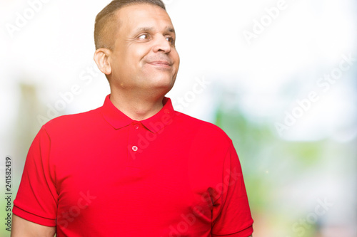 Middle age arab man over isolated background smiling looking side and staring away thinking.