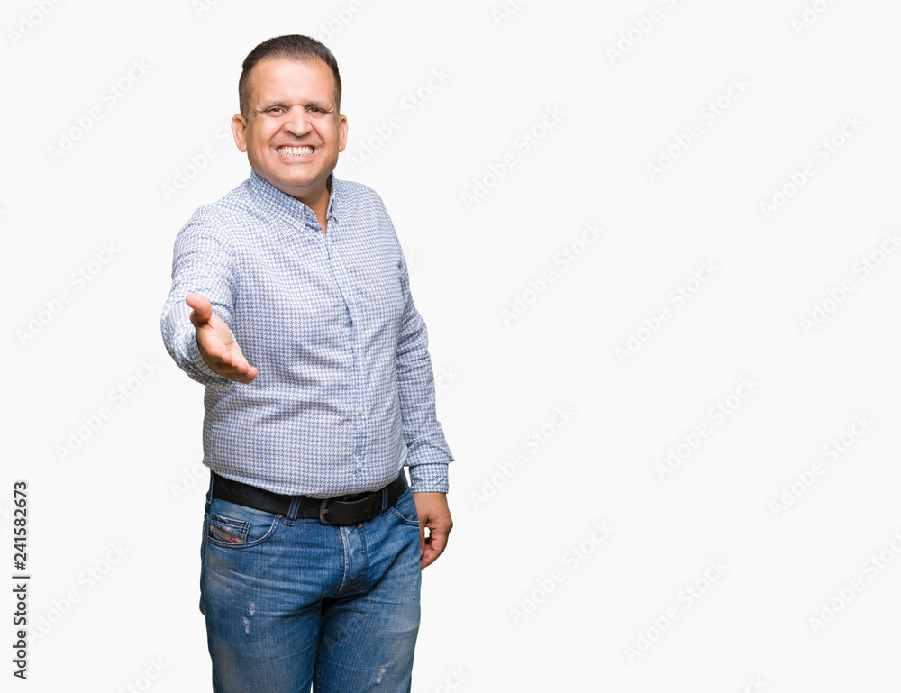Middle age arab business man over isolated background smiling friendly offering handshake as greeting and welcoming. Successful business. Middle age arab business man over isolated background smiling friendly offering handshake as greeting and welcoming. Successful business.